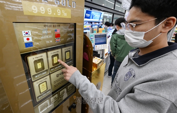 21일 편의점 GS25 강서 LG사이언스점에 설치된 금 자판기에서 한 시민이 금을 구매하고 있다. 미국 실리콘밸리은행(SVB) 파산 이후 국제 금융 위기 공포가 확산되는 가운데 편의점 자판기에서 6개월간 순금이 20억원어치 이상 팔렸다.
