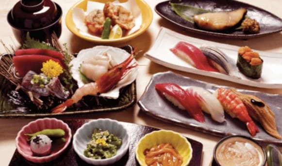 일본식 스시와 생선 요리등이 테이블위에 올려져 있다.