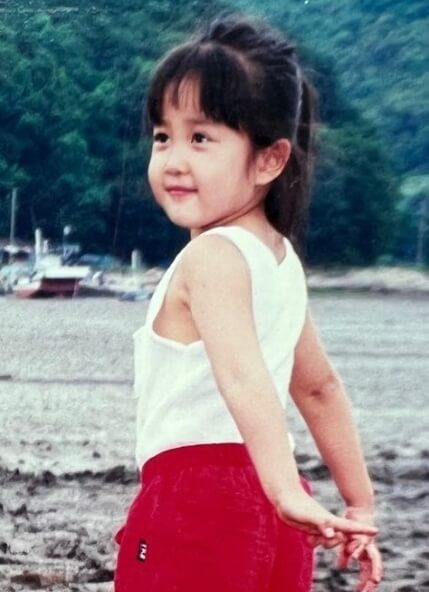 김다예 어린시절 모습&#44; 팔을 뒤로 하고 웃고 있습니다.