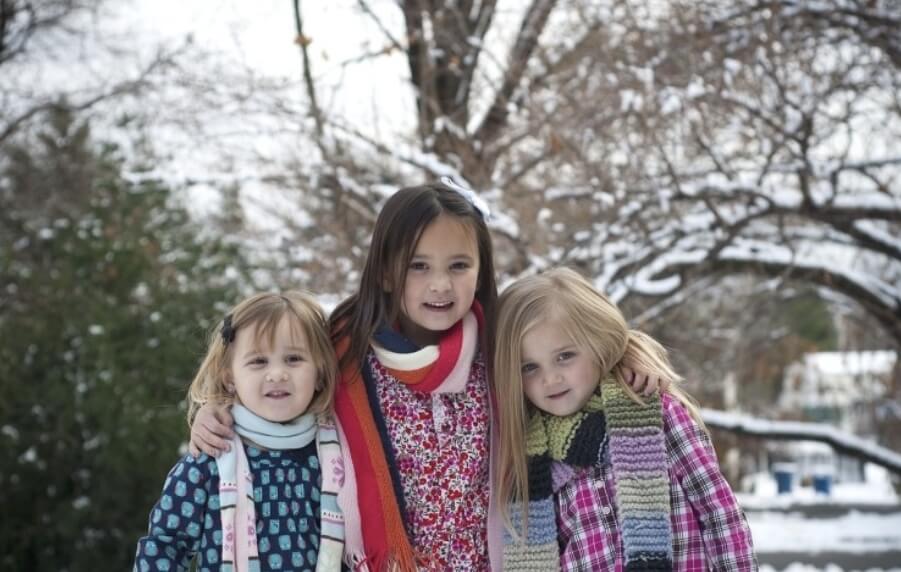 겨울에 세 자매가 나란히 서서 사진을 찍고 있다