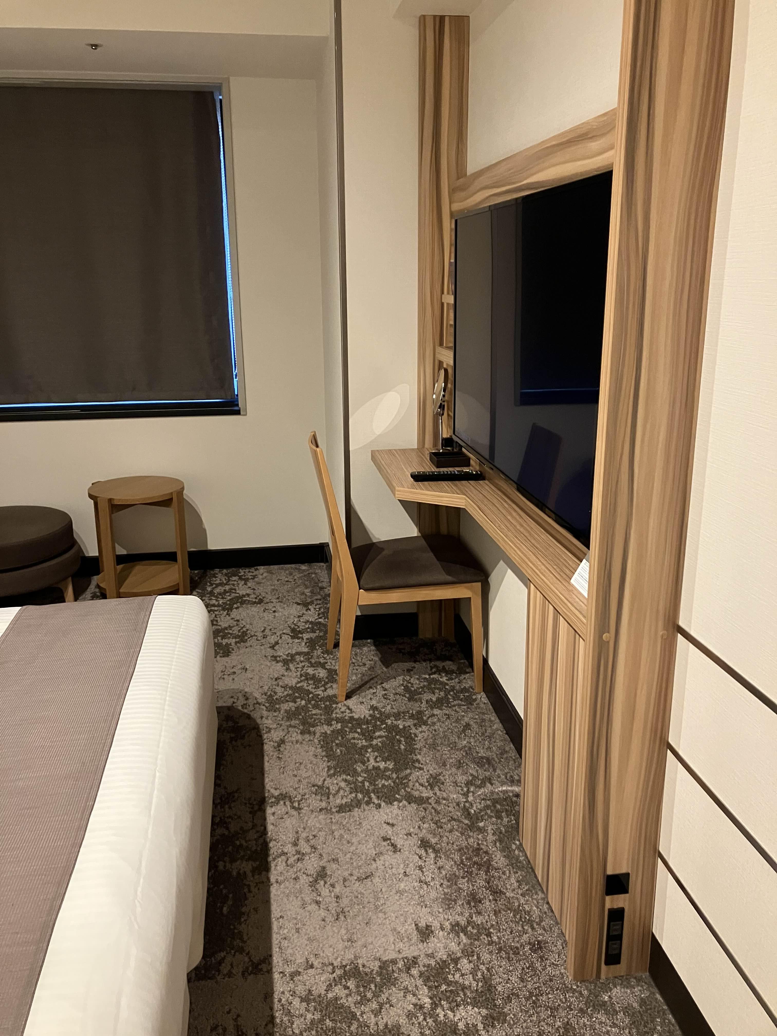 침대 옆에 위치한 TV와 미니 데스크