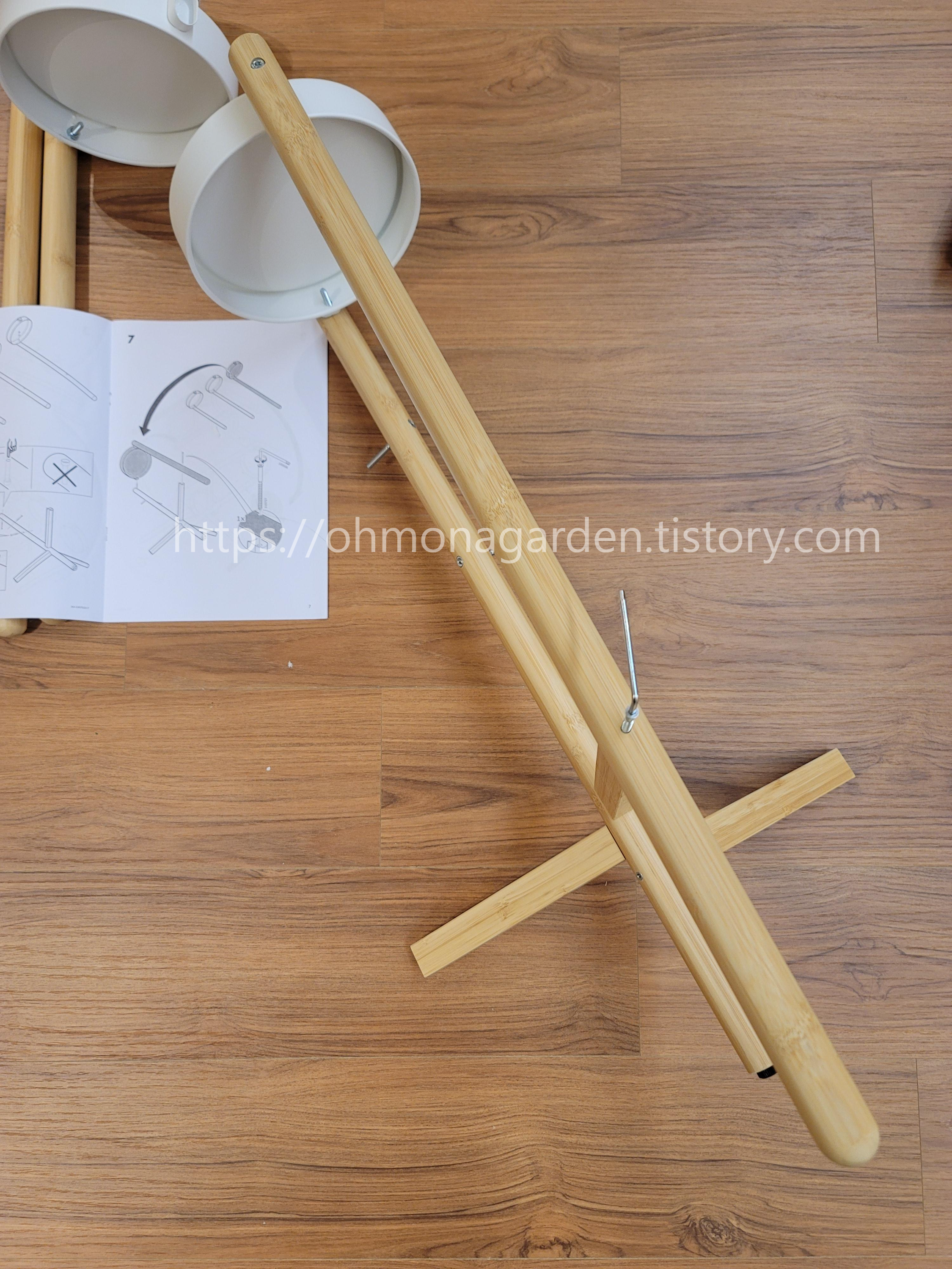 Attach the central pole of the IKEA SATSUMAS to the three legs with attached trays using screws.