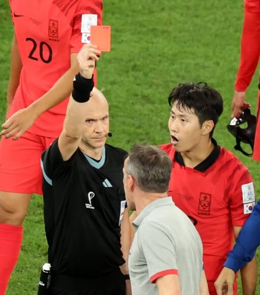 레드카드를들고있는남성과-축구유니폼을입고있는사람들의모습