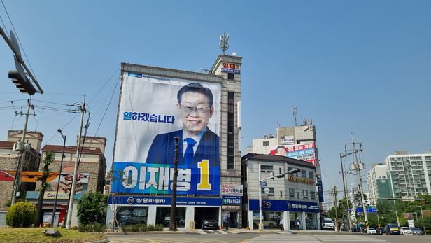  이재명 현수막 잘보이게 하려고 멀쩡한 가로수 가지 다 잘랐다? 구청 해명은 李 현수막 앞 가로수 3그루만 가지치기 인근 경쟁 후보 사무실 앞과는 다른 모습 구청 민원 누가 낸 것인지?