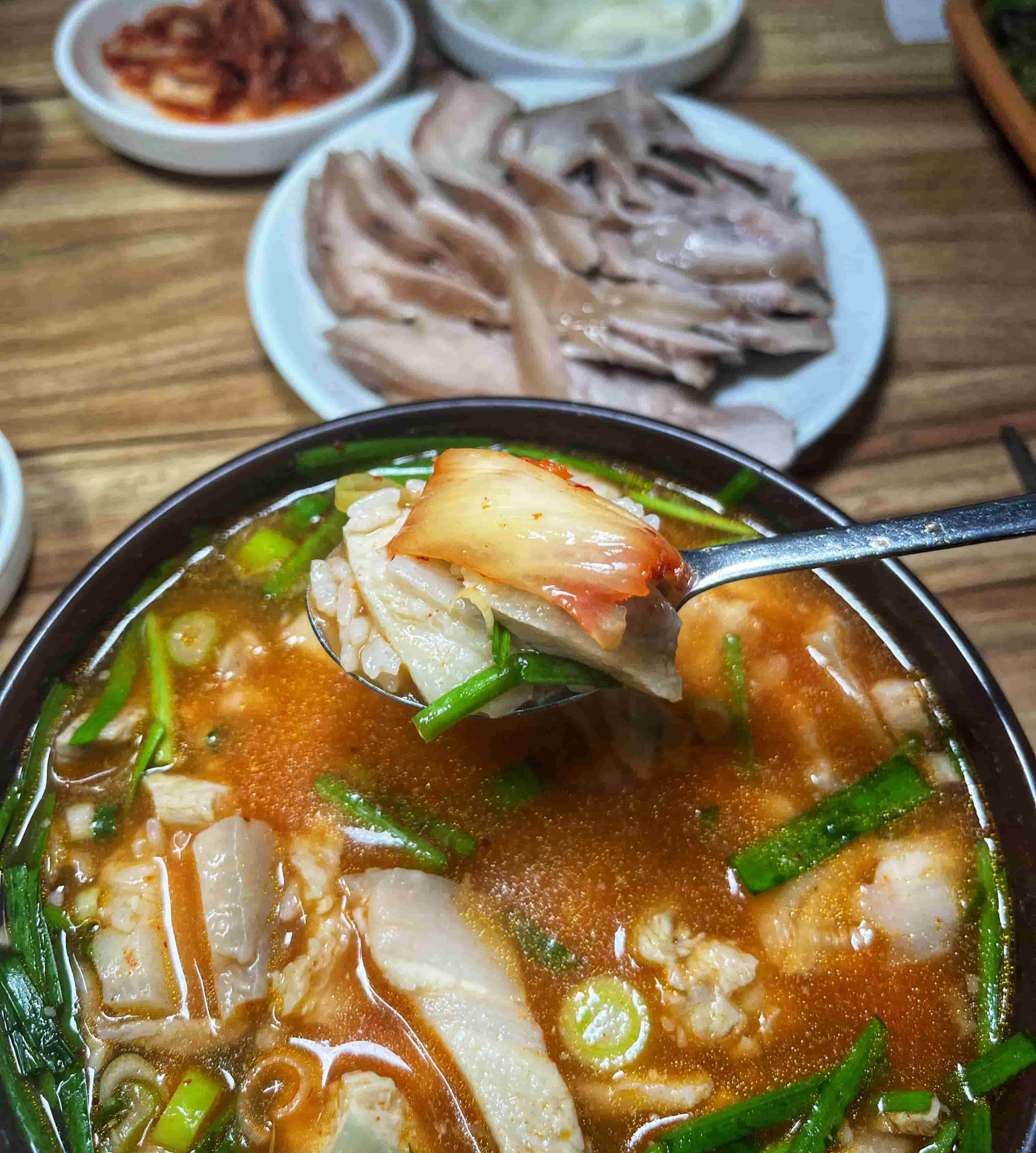 돼지국밥에 김치를 올려 먹는 사진
