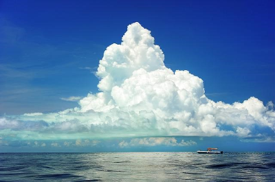 파란하늘 흰구름 바다 위 작은 배 한 척 떠 있는 풍경