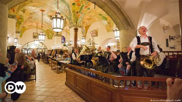 호프브로이하우스안에서 음악을 연주하는 악단과 맥주를 즐기는 사람들 사진