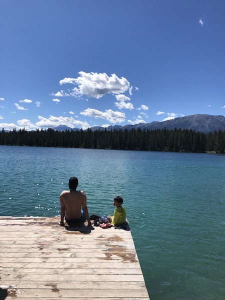 호숫가에 아빠와 아들이 앉아있는 모습