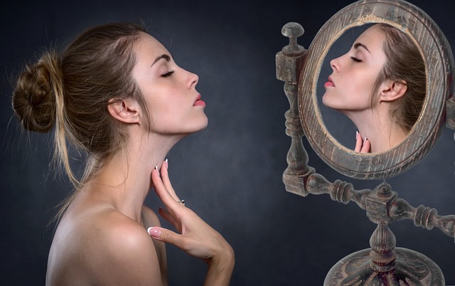 한 여성이 목주름 없애는 시술을 받기 전에 거울을 통해 목주름을 확인하고 있다