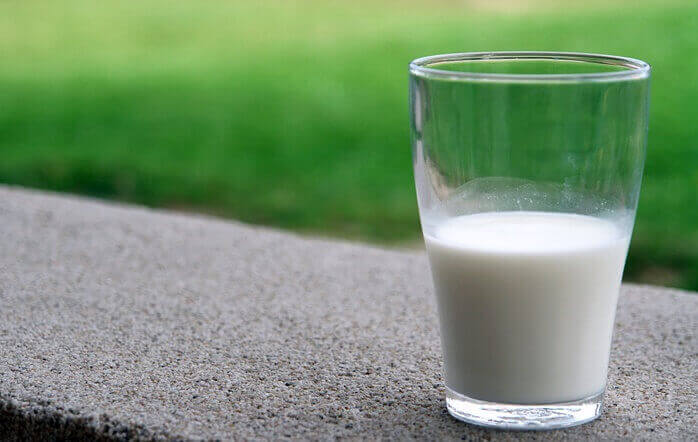 투명한 유리컵에 담겨있는 우유 