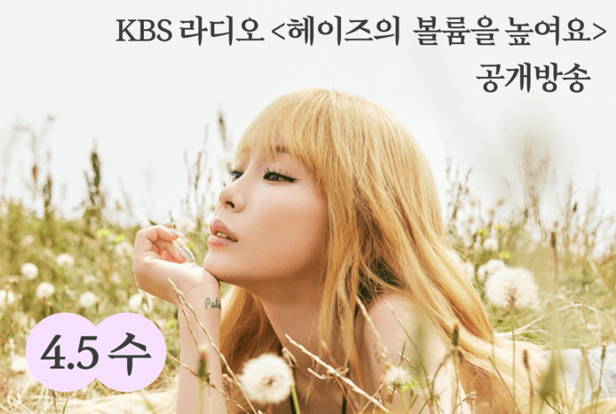 헤이즈가 꽃밭에 엎드려 포즈를 취하고 있는 모습