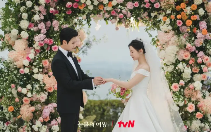 눈물의 여왕-
꽃이 가득한 결혼식장 왼쪽 검은 수트를 입은 김수현이 오른쪽 웨딩드레스를 입은 김지원에게 반지를 끼워주는 모습