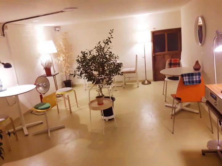 하얀조명에-가운데-큰화분이있고-테이블이-세개에-각각-의자가-놓여있는-사진