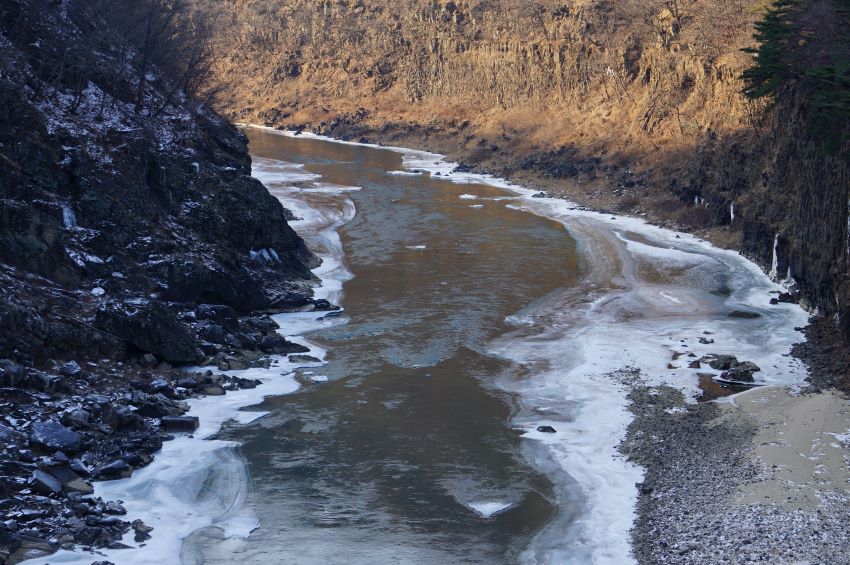 좌 우에 절벽&#44; 왼쪽은 그늘&#44; 우측은 양지&#44; 가운데를 흐르는 강물&#44; 얼어붙은 강변&#44;