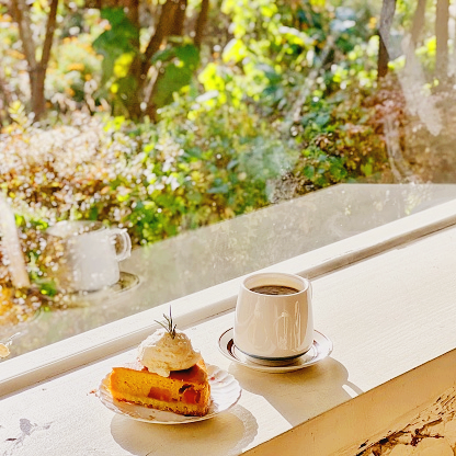창가에 디저트와 커피가 놓여있는 사진
