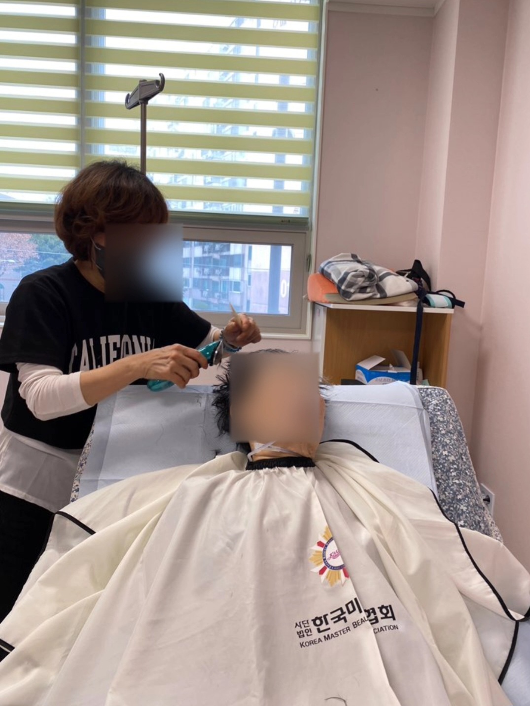 누워 계신 어르신의 머리를 손질하는 모습