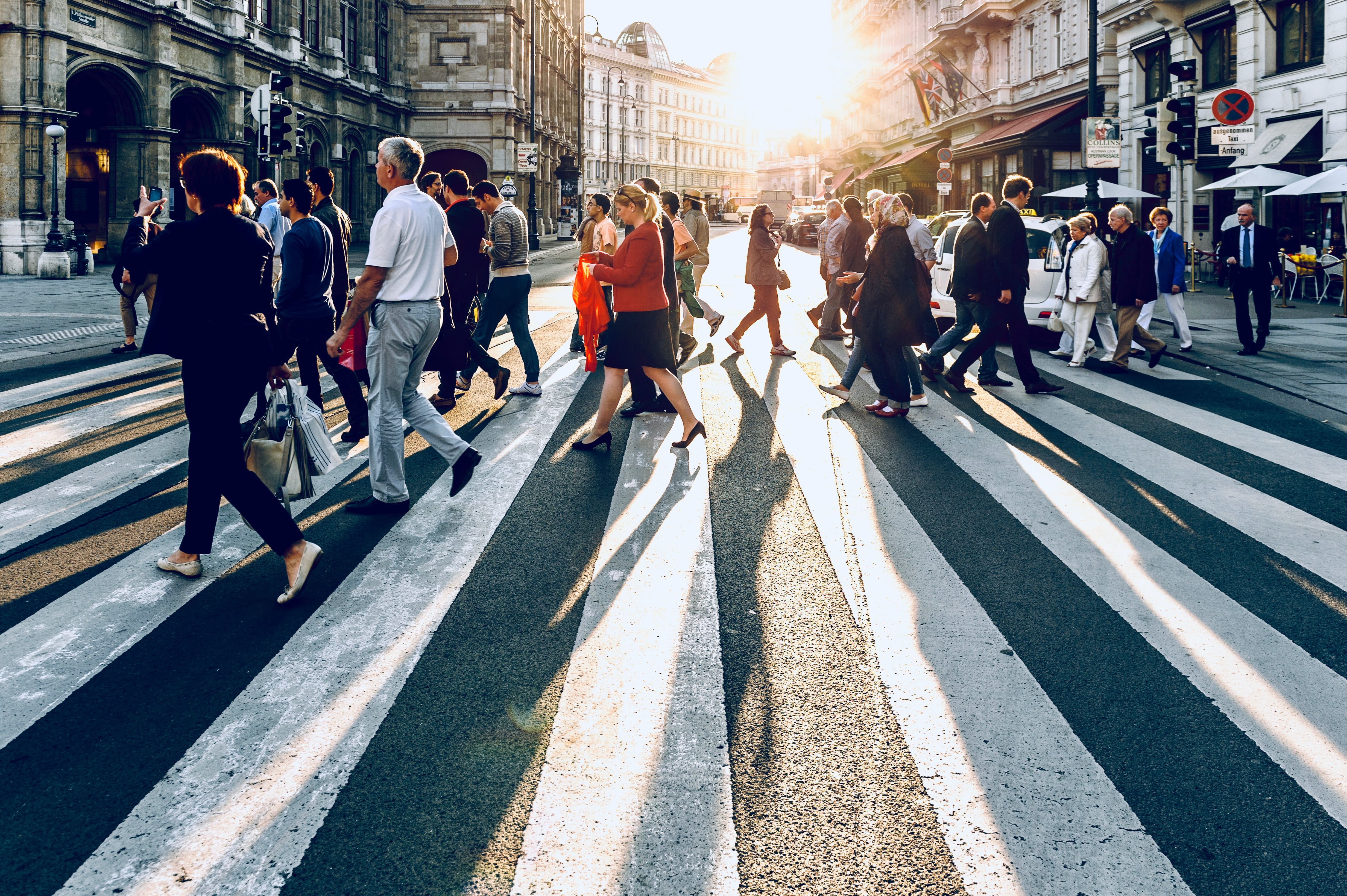 Many people walking on a crosswalk