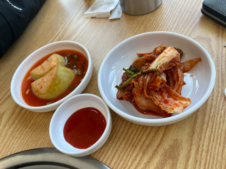 테이블-위-하얀색-둥근-접시에-담긴-김치