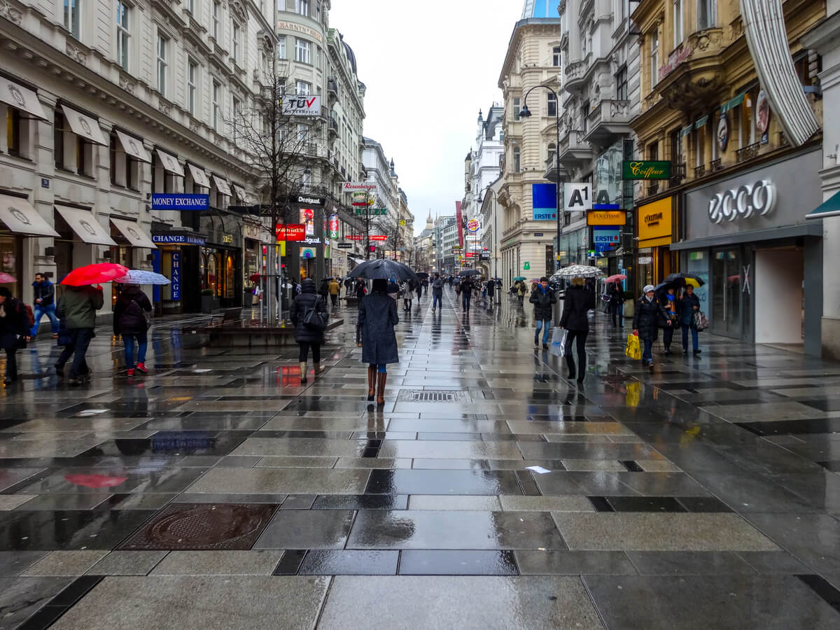 비오는 오스트리아 비엔나의 건물들과 우산을 쓴 사람들