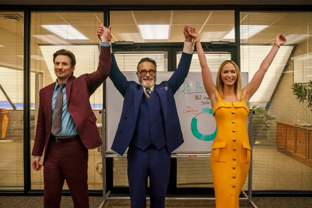 배우 세명이 사무실에서 다들 손을 번쩍 들고 있는 모습의 영화 장면