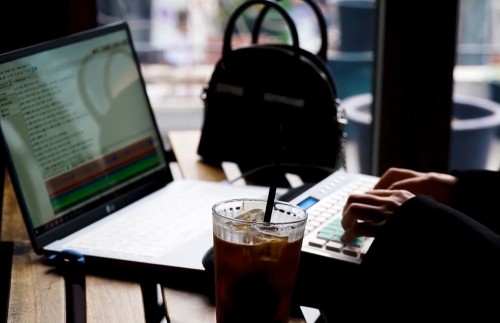컴퓨터 전문 프리랜서가 카페에 앉아 자유롭게 일하는 사진