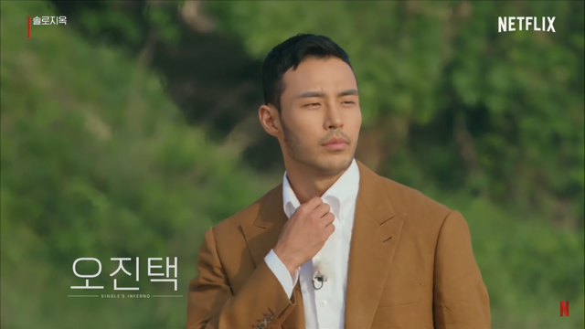 털의 남자, 오진택이 갈색 양복을 입고 흰색 와이셔츠를 걸쳤네요