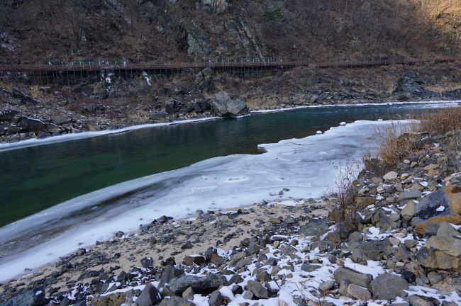 건너편에 데크길&#44; 짙푸른 강물&#44; 우측에 넓게 얼어붙은 강물&#44;