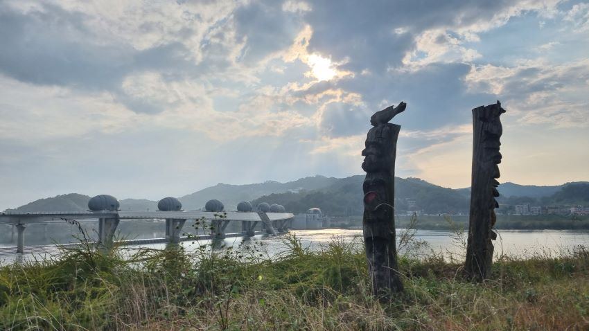 남한강을 가로지른 이포보&#44; UFO처럼 보이는 이포보 위의 둥근 조형물 6개&#44; 흐린 하늘&#44; 우측에 우뚝 선 장승 2&#44;
