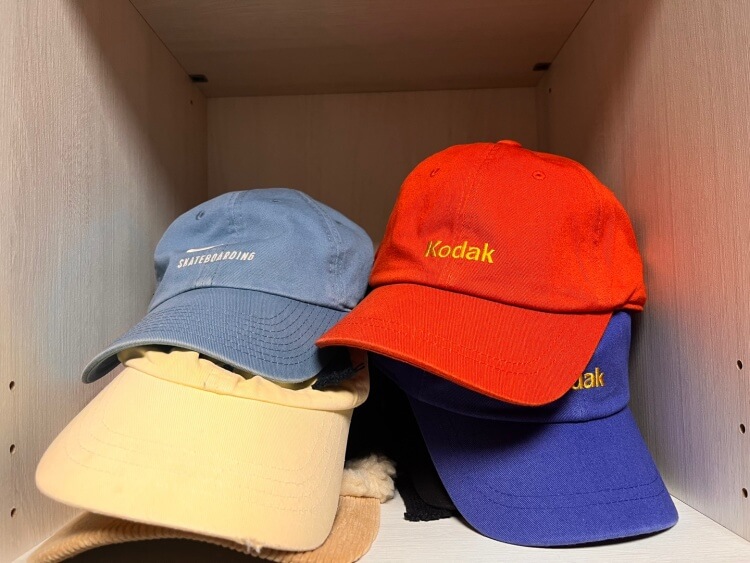 옷 장에 놓여있는 코닥 모자와 다른 브랜드의 모자