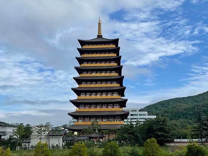 푸른 구름을 배경으로 경주 더케이 호텔에서 바라보는 황룡원이 우뚝 서있는 웅장하고 멋진 건물의 사진으로 황룡사 구층탑의 양식으로 건설된 황룡원 연수원 사진