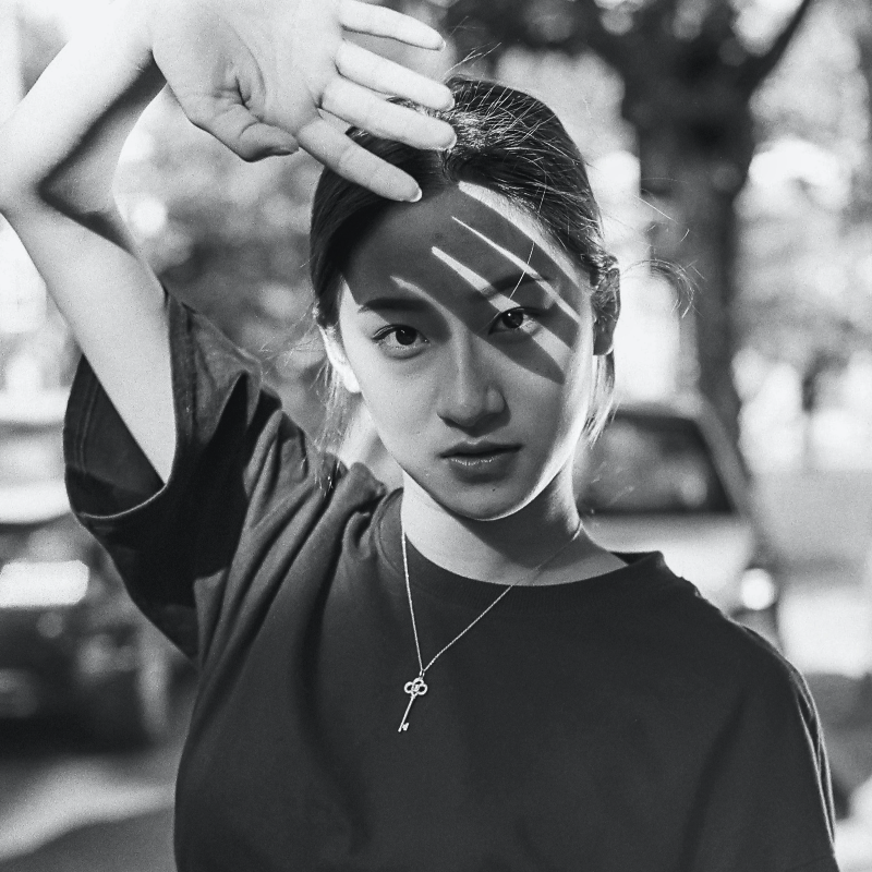 젊은-여성이-손으로-햇빛을-가리며-정면을-보는-장면