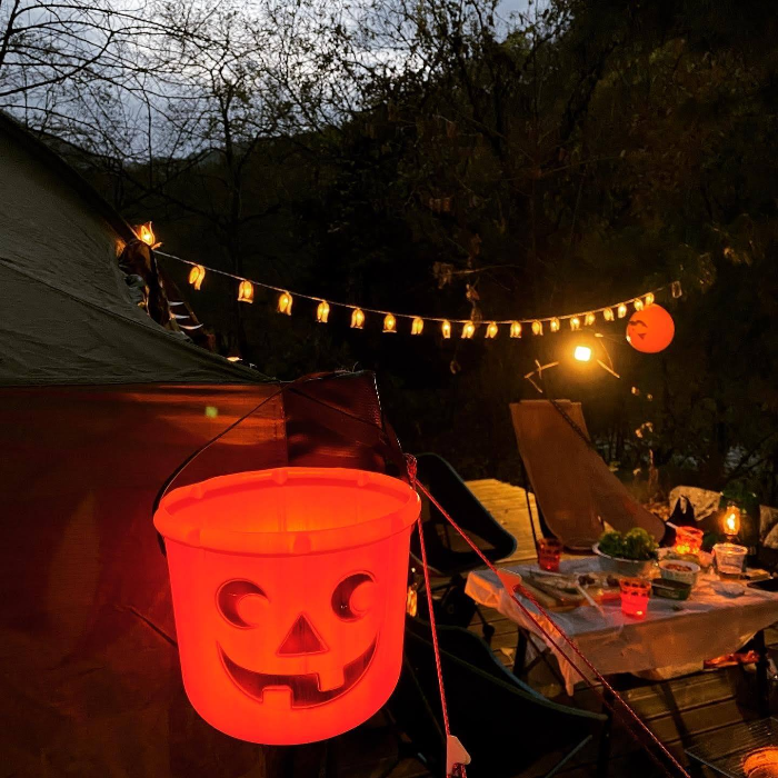 할로윈 캠핑 소품 - 잭오랜턴 바구니에 캠핑용 조명을 넣어두면 불빛 색이 오렌지색으로 바뀐다.