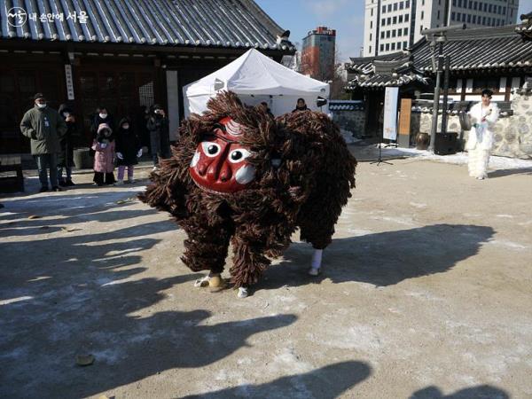 '액운타파 사자난장' 공연에서 사자가 올해 일어난 나쁜 일들을 담은 박을 깨고 있다. 