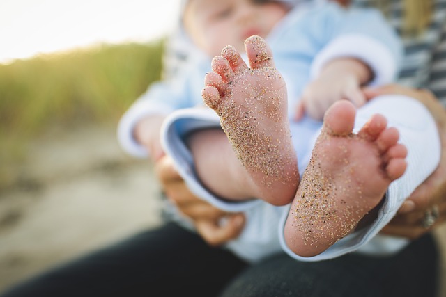 아기의 발에 모래가 뭍어 있는 귀여운 사진