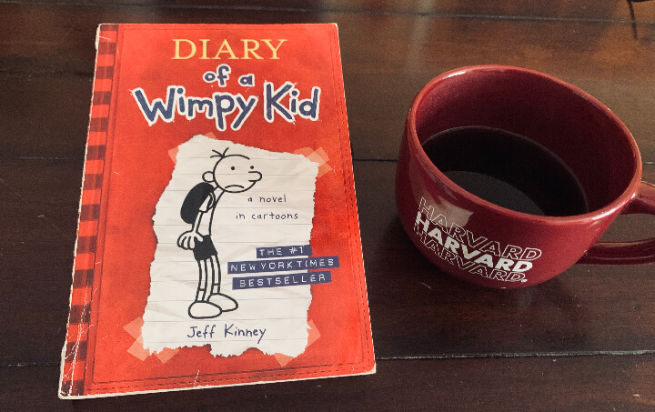 Diary of a Wimpy Kid by Jeff Kinney 책 한권과 커피잔 하나의 사진