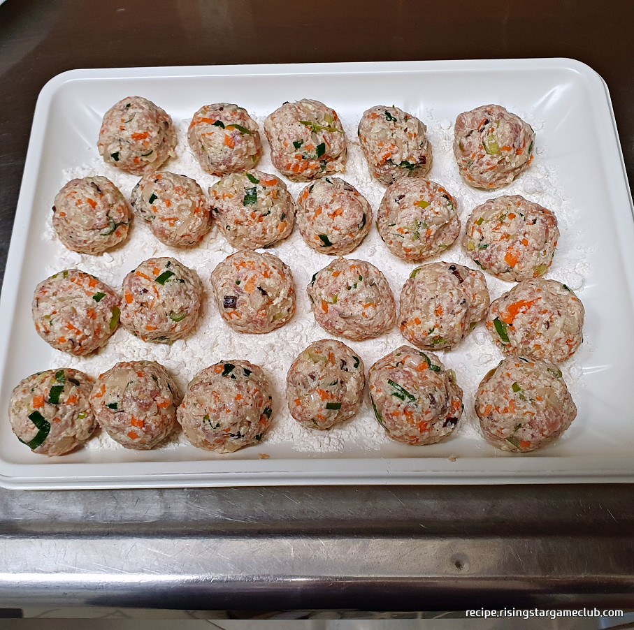 맛있는 동그랑땡 반죽을 동그랗게 뭉쳐서 밀가루가 있는 쟁반위에 올려 놓은 사진