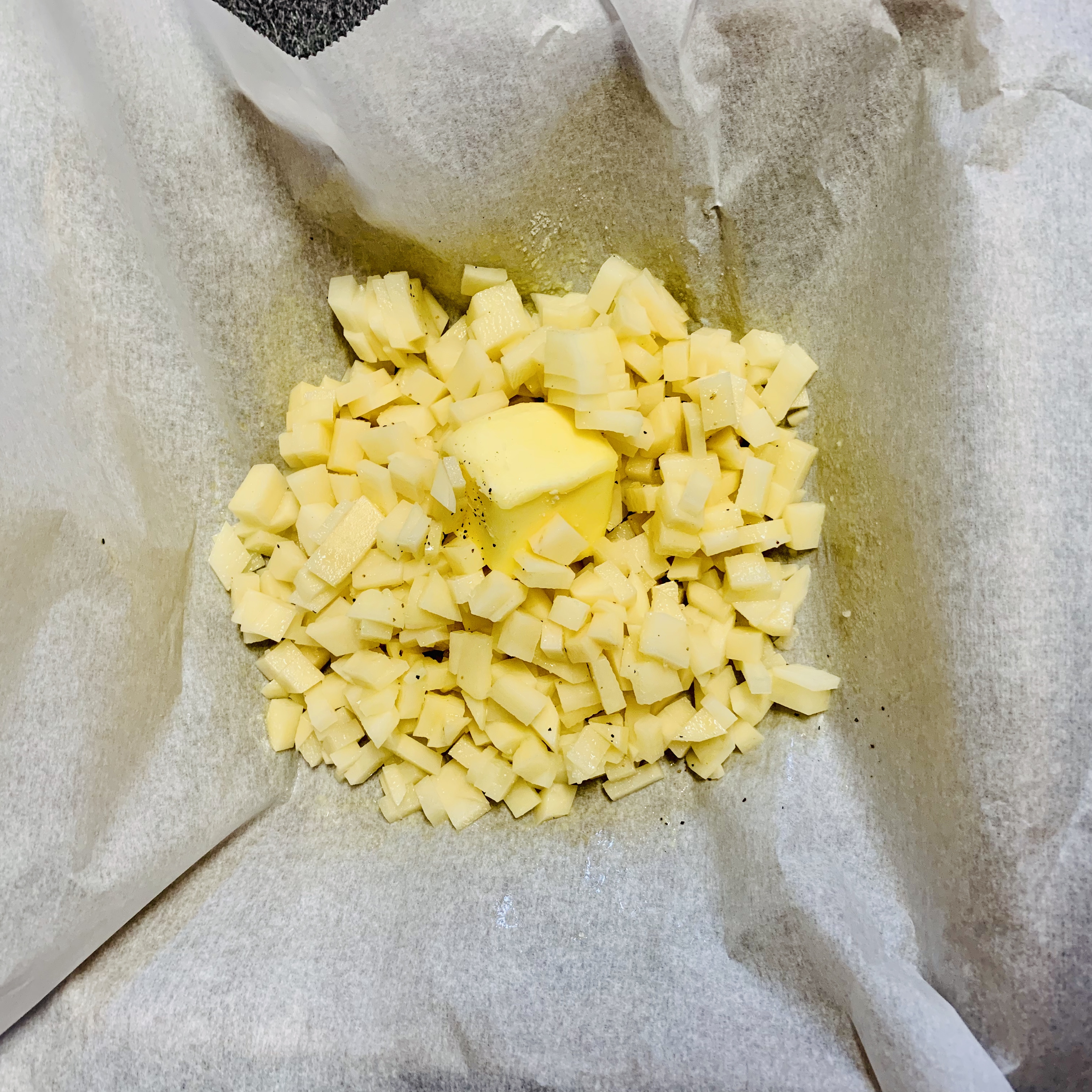 흰색-종이-위에-노란색-큐브모양-감자와-노란-버터가-보이는-모습