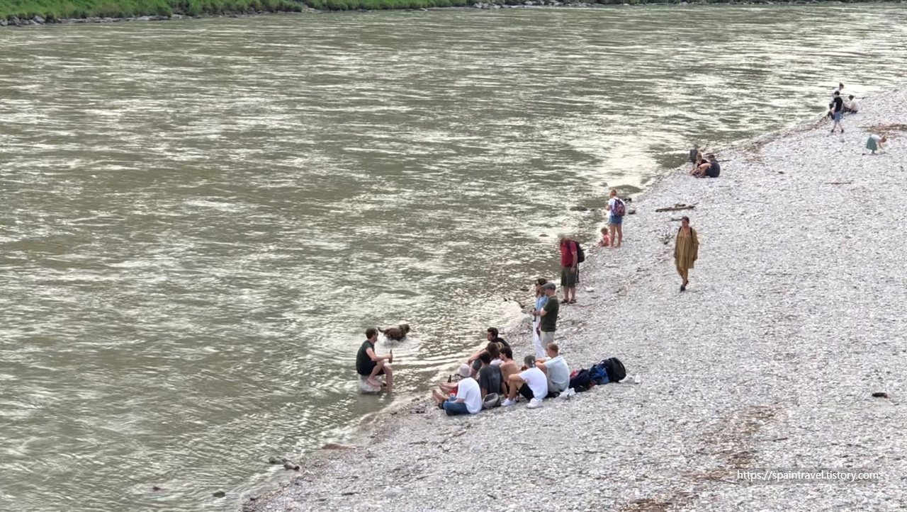 다리 아래 Salzach 강에서 여유를 즐기는 사람들