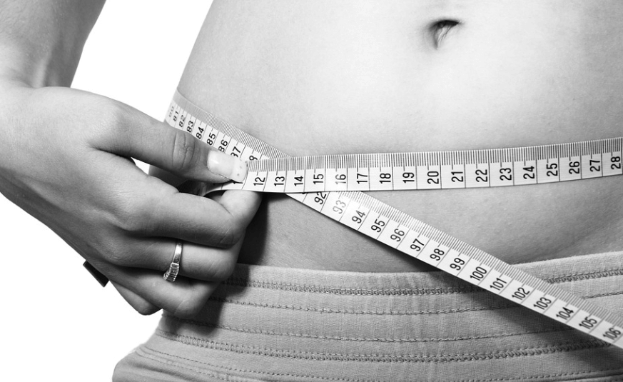 다슬기 효능은 다이어트에 도움이 된다. 줄자로 허리 사이즈를 확인하고 있는 여성