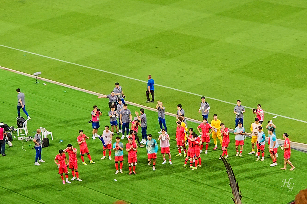 한국인 관중석을 향해 인사하고 서로 독려하는 붉은 유니폼의 한국 선수단
