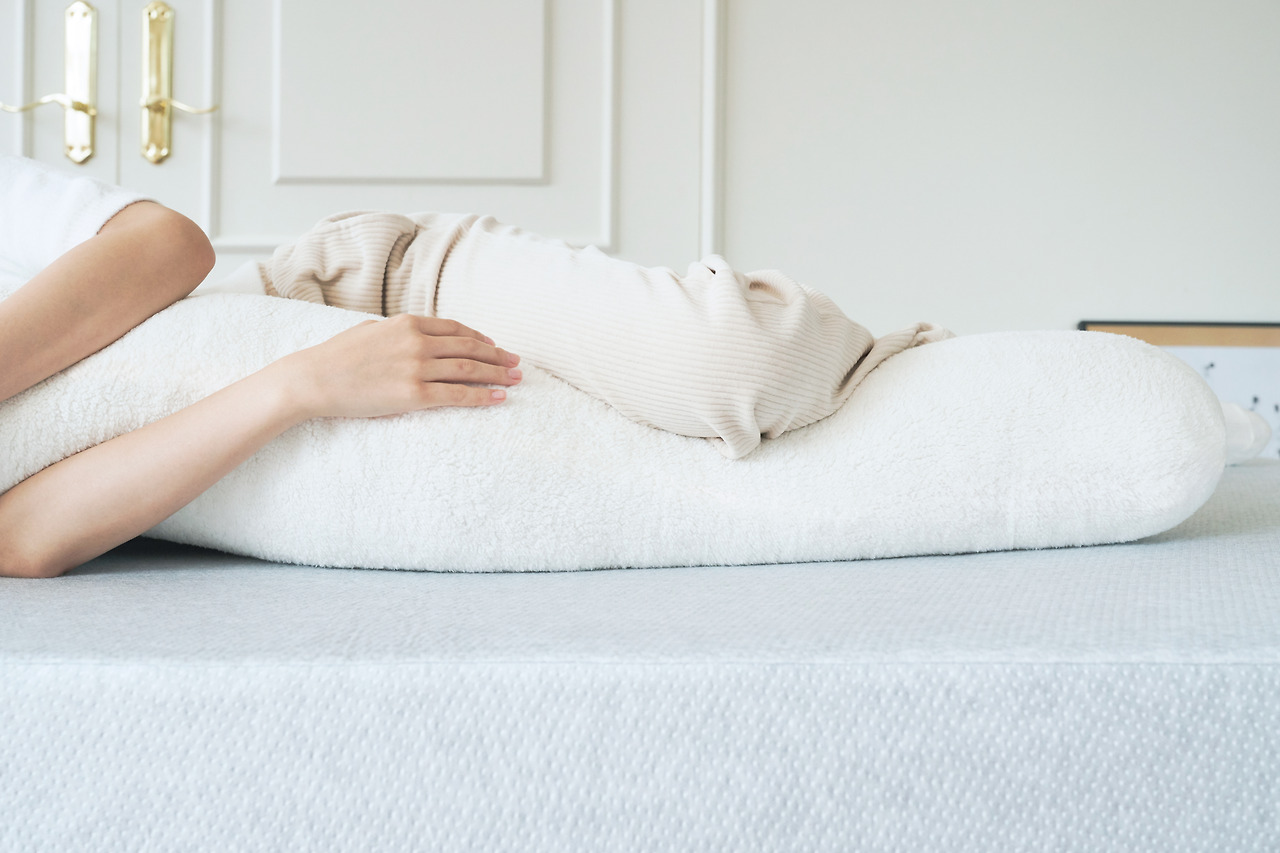 측면으로 베개를 안고 있는 사진