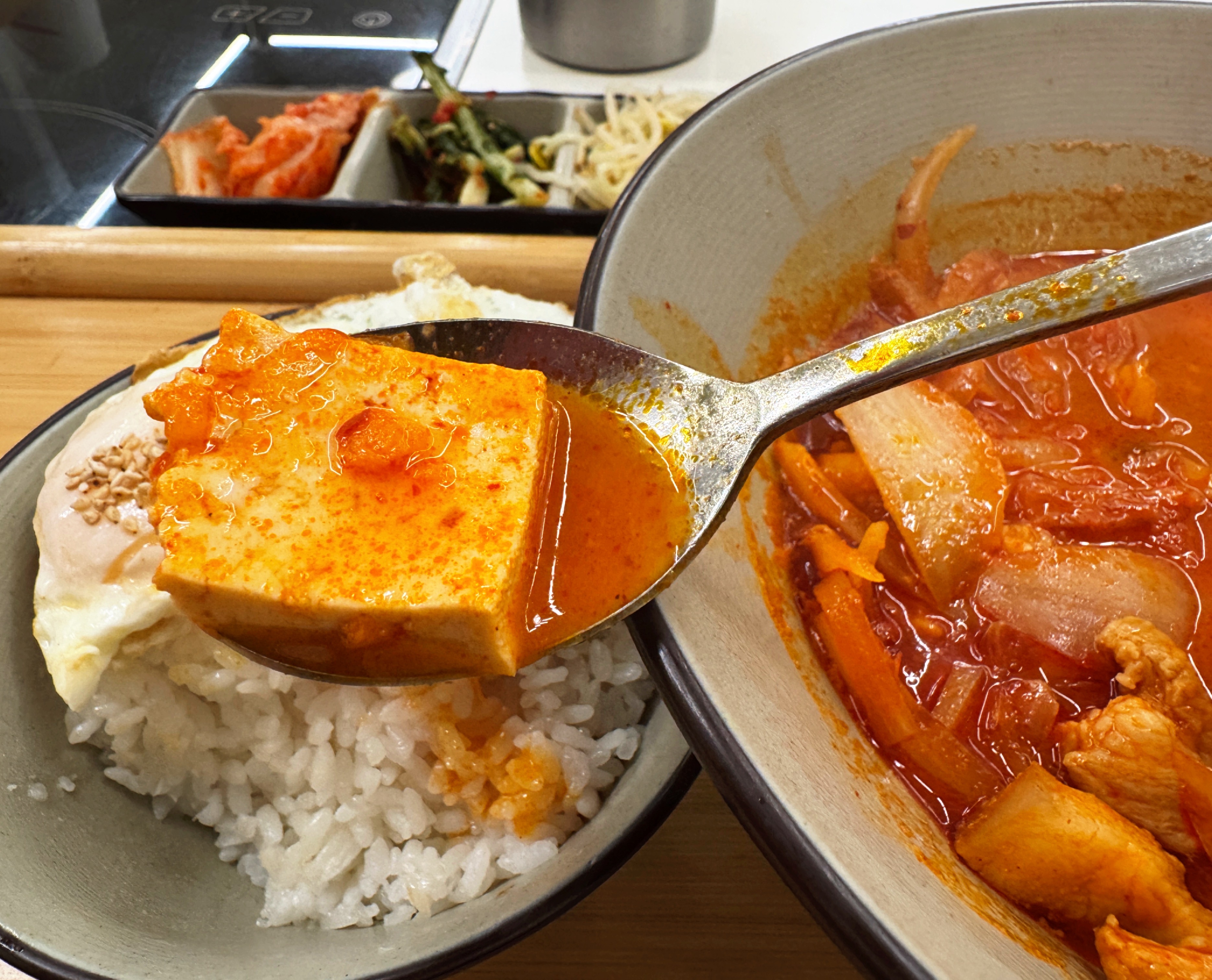 용인 수지구 동천동 바른식탁 김치찌개 건더기 클로즈업. 큼직한 두부 한 조각을 숟가락으로 뜬 모습&amp;#44; 