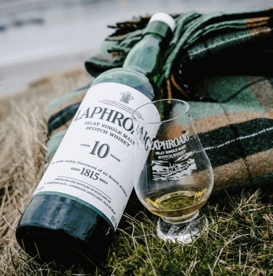 잔디 위 라프로익 10년과 위스키잔과 목도리