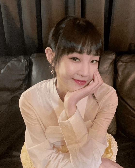 박보람이-살구색-블라우스를-입고-왼손을-턱에-괸-채-소파에-앉아-옅은-미소를-띄고-있는-사진