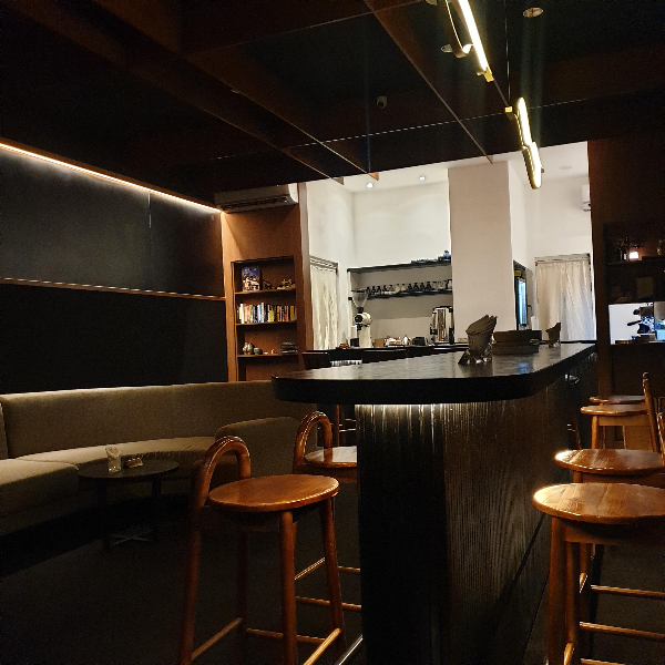 전체적으로 어두운 카페 내부 검은색 테이블과 우드 체어가 고급스럽다.