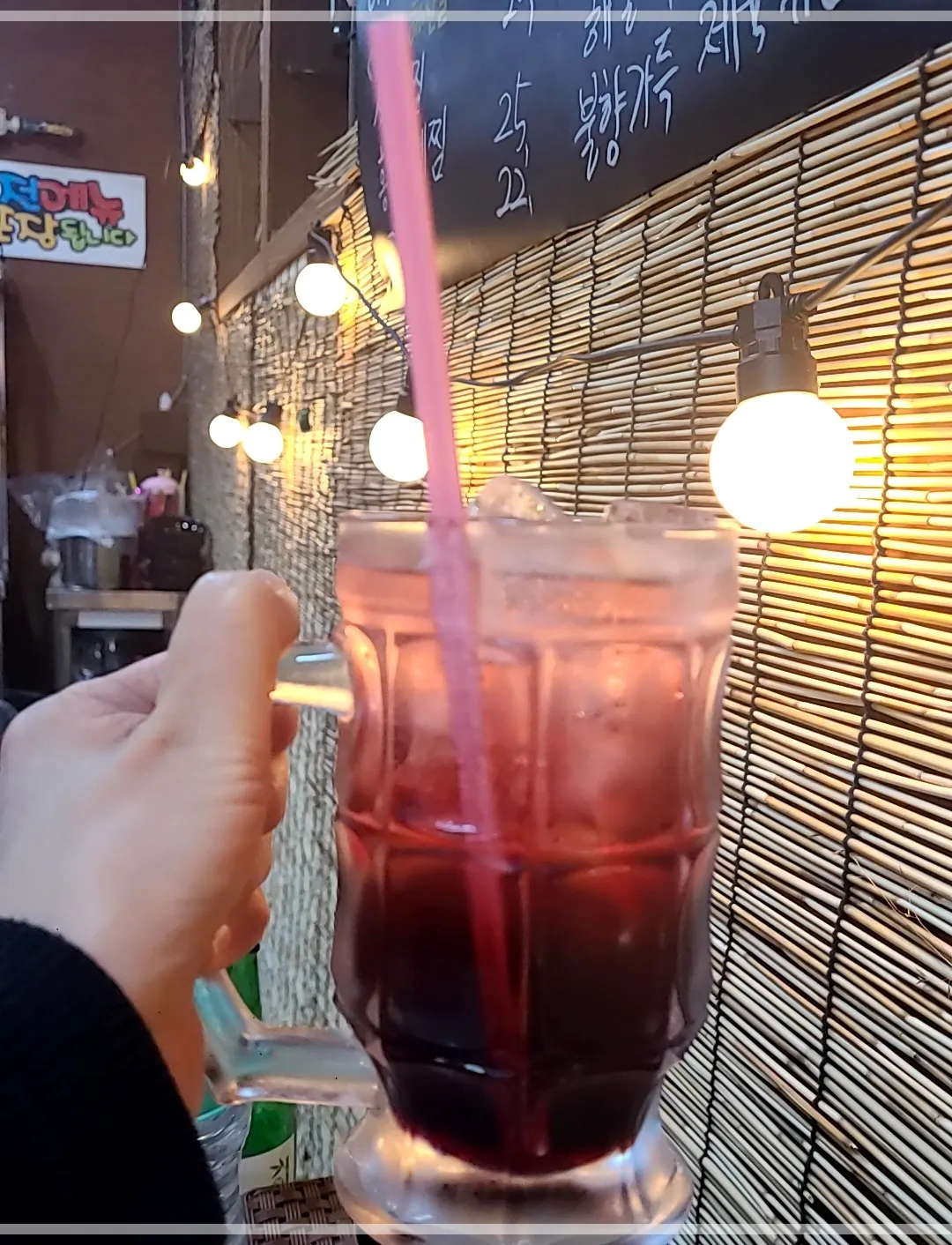 복분자하이볼을 여자손이 들어올린 모습