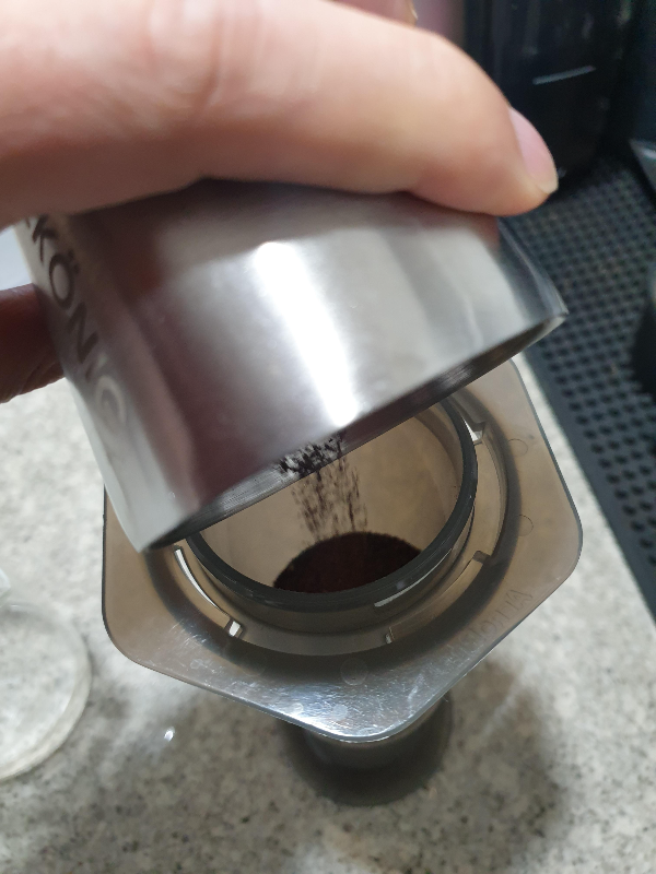 에어로 프레스에 원두를 투입하고 있다.