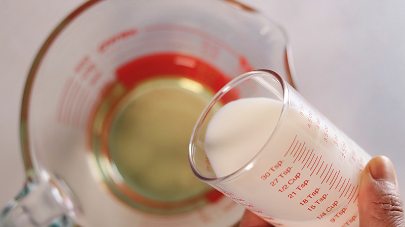 우유를 기름이 담긴 컵에 붓는다