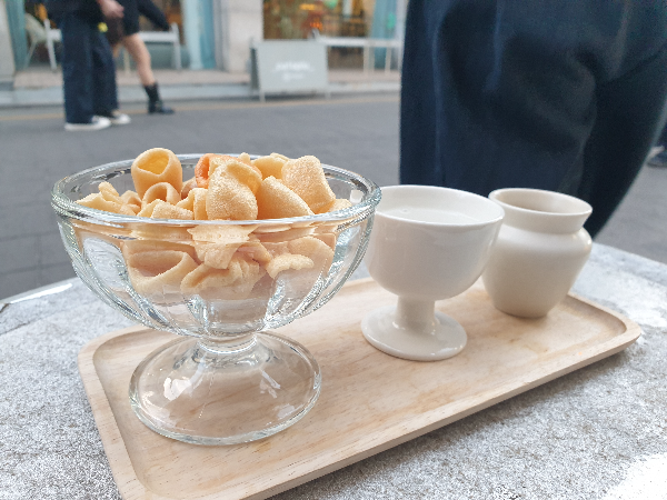 서비스 과자가 유리 그릇에 담겨 있고, 두개의 술잔이 올려져 있다.