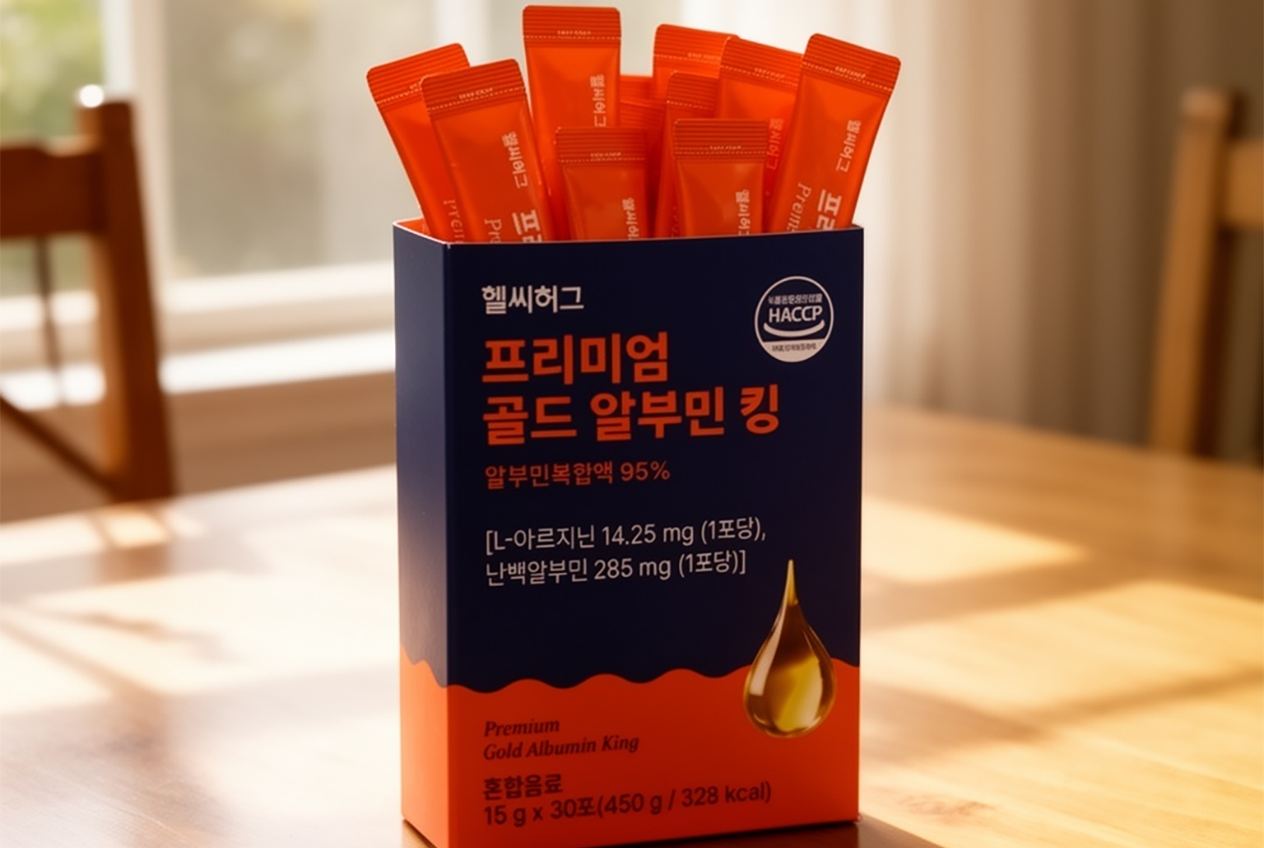 헬씨허그 프리미엄 골드 알부민 킹 제품 박스, 네이비 블루와 오렌지 컬러로 디자인되어 있고 박스 안에 오렌지색 스틱 포들이 세워진 모습, 자연광이 비치는 원목 테이블 위에 놓인 제품 사진